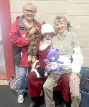 Even the adults wanted a turn sitting on Santa’s lap and telling him their Christmas wishes at the Mid-Winter Fair. Shown here with Santa are Carol Odenbach, l, and Sharon Nebola.