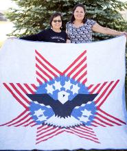 Wilma, l, and Lisa show the star quilt made by Wilma’s mother, Velda Bearshield, that incorporates an eagle into the star design. Velda made the quilt when her son, Willie Bearshield, was in Desert Storm. (Photo from Quiltfolk, used with permission)
