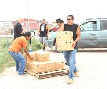 Volunteers help unload boxes of food for children across the Pine Ridge Reservation as part of a summer food program.