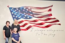 Pictured with the new mural at the American Legion Hutchison Post #6 is Darrell Jones’ wife Sandra and their two daughters Susan Jones Berg (l) and Tara Jones Kiley (r).