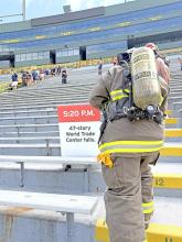 Mark Braun, in full turnout gear, makes his way up to the 47th story. An already emotional climb, the sign is a reminder of when the tower fell.
