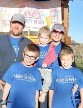 On wish fulfillment day, Make-A-Wish arranged a celebration that included pizza, cupcakes, balloons, and tshirts for Evie, her family, and friends. She is shown here with her parents Jake and Jacinta, and brothers, Jason and Josh, in front.