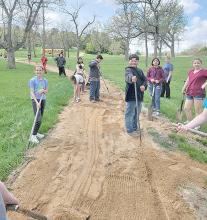 Some freshmen came up with the idea to improve the fitness trail at the park. They scooped the agrilime back onto the path, smoothed it out, and packed it down.