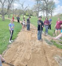 Some freshmen came up with the idea to improve the fitness trail at the park. They scooped the agrilime back onto the path, smoothed it out, and packed it down.