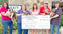 First Fidelity Bank and Gregory Community Foundation presented a $1,500 grant check to Rescues Unlimited, which has saved hundreds of animals, to use for upcoming projects. Representing Rescues Unlimited, from left to right, are Rose McCaulley, holding Moo-Moo, Marie Palmer with Arlo, Rhonda Vaughn-Waterbury (Gregory Foundation board member), Joey Meyers with Wessell, and John Watts holding Caramel.