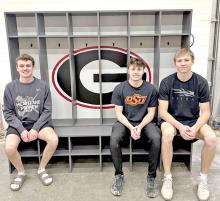 Ryler Stevicks, Pierce Stukel, and Colt Keiser, shown l to r, sit on the new lockers they built for the community weight room. (Photo from Facebook)