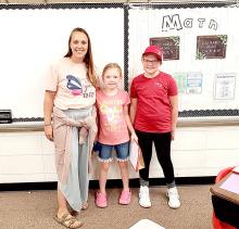 Second grade teacher Britany Reber welcomes her new student Kate and sister Madeline Engel to the new year.