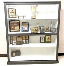 The trophy case is a legacy piece salvaged from the old school. It was refurbished by the class of 2026, and is destined to live a second life in the new school where it is already filling up with awards and trophies.