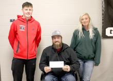 Cruz Klundt, the student body president presenting a check to Justin Weiss and Ashley Sengelmann.