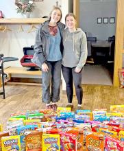 Gregory High School student council members Asia VanDerWerff (left) and Dani Timanus dropped off 50 boxes of cereal to Rosebud Electric Cooperative for the annual holiday cereal drive. The donation was purchased with money raised from the Gregory school's hat and pajama day.
