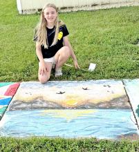 Kylie Schell beams in front of her winning sidewalk square, a detailed nature scene, that captured the hearts of voters in the Fourth of July Art Walk competition.