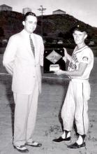 Wayne McCollum, team captain of the 1954 Jr. Legion State B championship baseball team, is being presented with the runner-up plaque from the overall state tournament series.