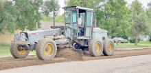 Public Works Superintendent Josey Larsen spreads gravel on Rosebud Avenue in preparation for milling. After the streets have been milled, they will be resurfaced. A total of 42 blocks are slated for resurfacing this summer. The project is expected to be completed by the end of August.