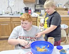 Joey and Bentley mix up the ingredients for peanut butter cookies.