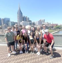 The group is shown here posing with the Nashville skyline in the background.