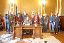 Pictured from l to r: Robert Perry and Tyler Stein of the Department of Public Safety; District 21 Representative Jim Halverson; District 26 Representative Rebecca Reimer; District 21 Representative Marty Overweg; Lt. Gov. Tony VenHuizen; Governor Larry Rhoden, seated; Mid-Missouri PBA board members, Brad Christensen, Heather Hammerbeck, and Tom Hausman; District 21 Representative Mykala Voita; Mid-Missouri PBA board member Sara Grim; SDSU Extension Agent Sean Kelly; and legal counsel Stacy Hegge.