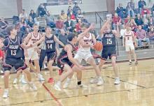 Landon Keiser is surrounded as he tries to move toward the basket. (Photo by JMe Braun)