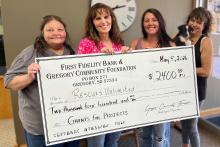 Pictured from left to right are Marie Palmer from Rescues Unlimited, Rhonda Vaughn-Waterbury and Aliza Wonnenberg, First Fidelity Bank &amp; Gregory Community Foundation board members, and Raquel Opbroek, also from Rescues Unlimited, holding Badger.
