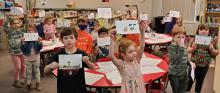 The kindergarten class proudly displays their fingerprint art.