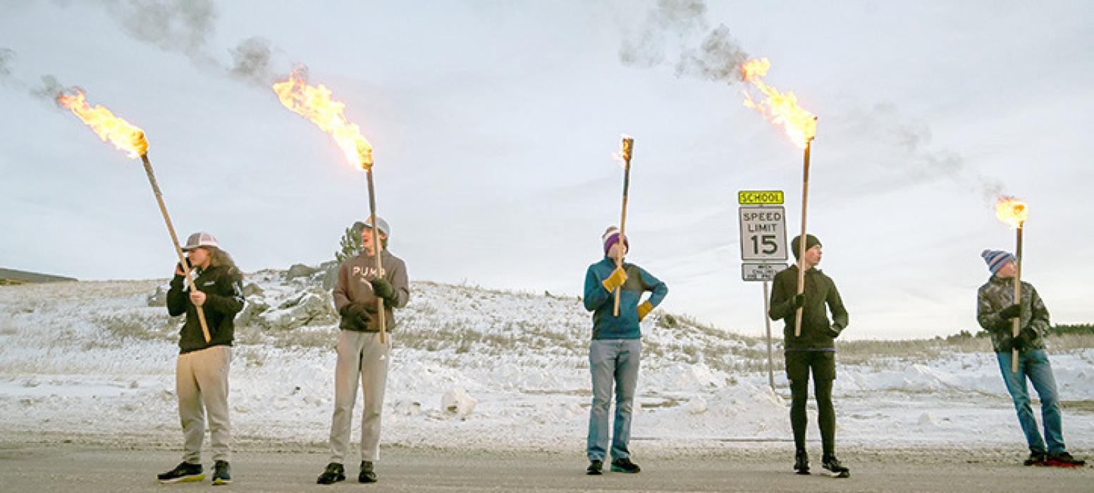 People carry torches en route to the beetle before setting it on fire during the 11th annual Burning Beetle event on Saturday, Jan. 20, 2024, at Pageant Park in Custer, S.D. The event was created in response to the Mountain Pine Beetle infestation a few years ago and continues to raise awareness of the impact of the beetles. (Matt Gade/Rapid City Journal via AP)