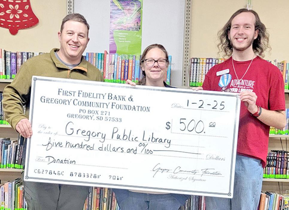 Mark Braun, representing the Gregory Community Foundation, presents a $500.00 grant to Tara Engel, librarian, and Christian Spann to be used at the Gregory Public Library.