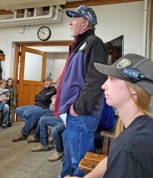 John Parsons, standing, expresses his support for the 2A sanctuary petition as Mykala Voita, the presenter of the resolution, seated next to him, listens.