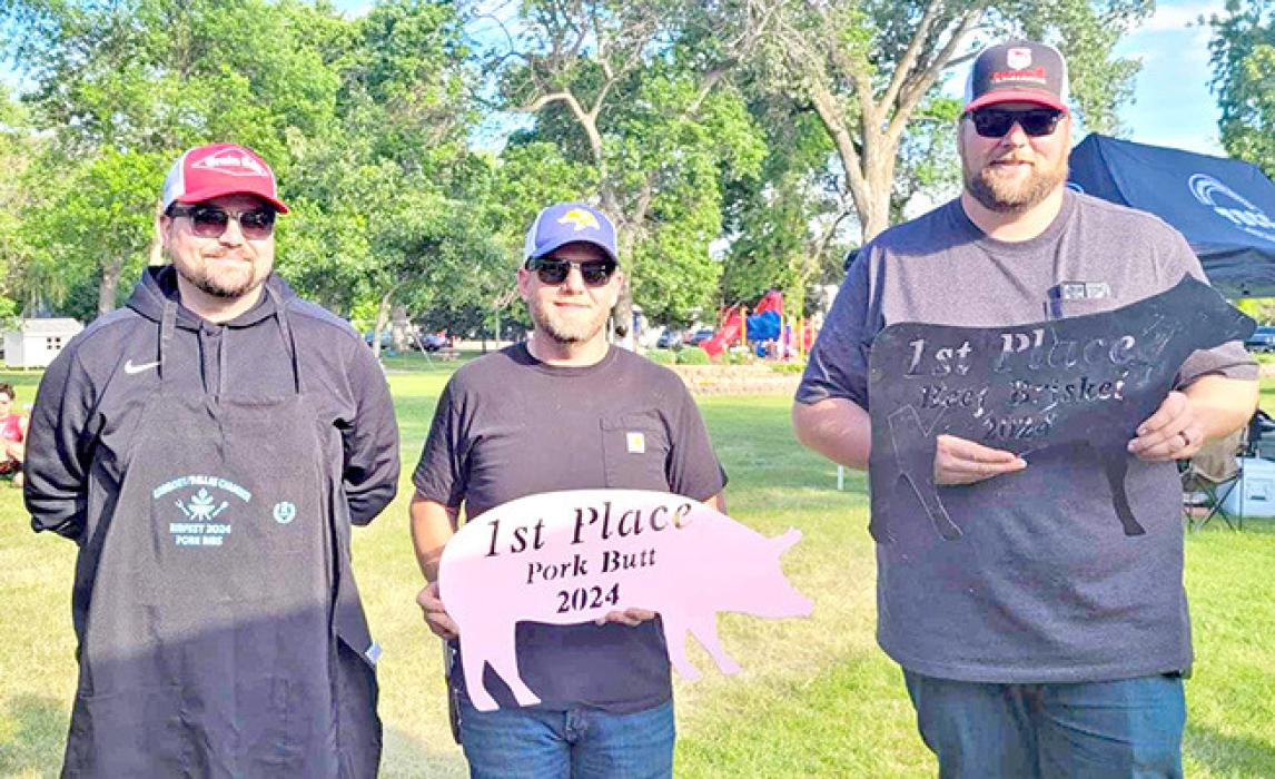 Joel Bartling, Casual Smoker, far right, is assisted in holding his two trophies - pulled pork and brisket champ.