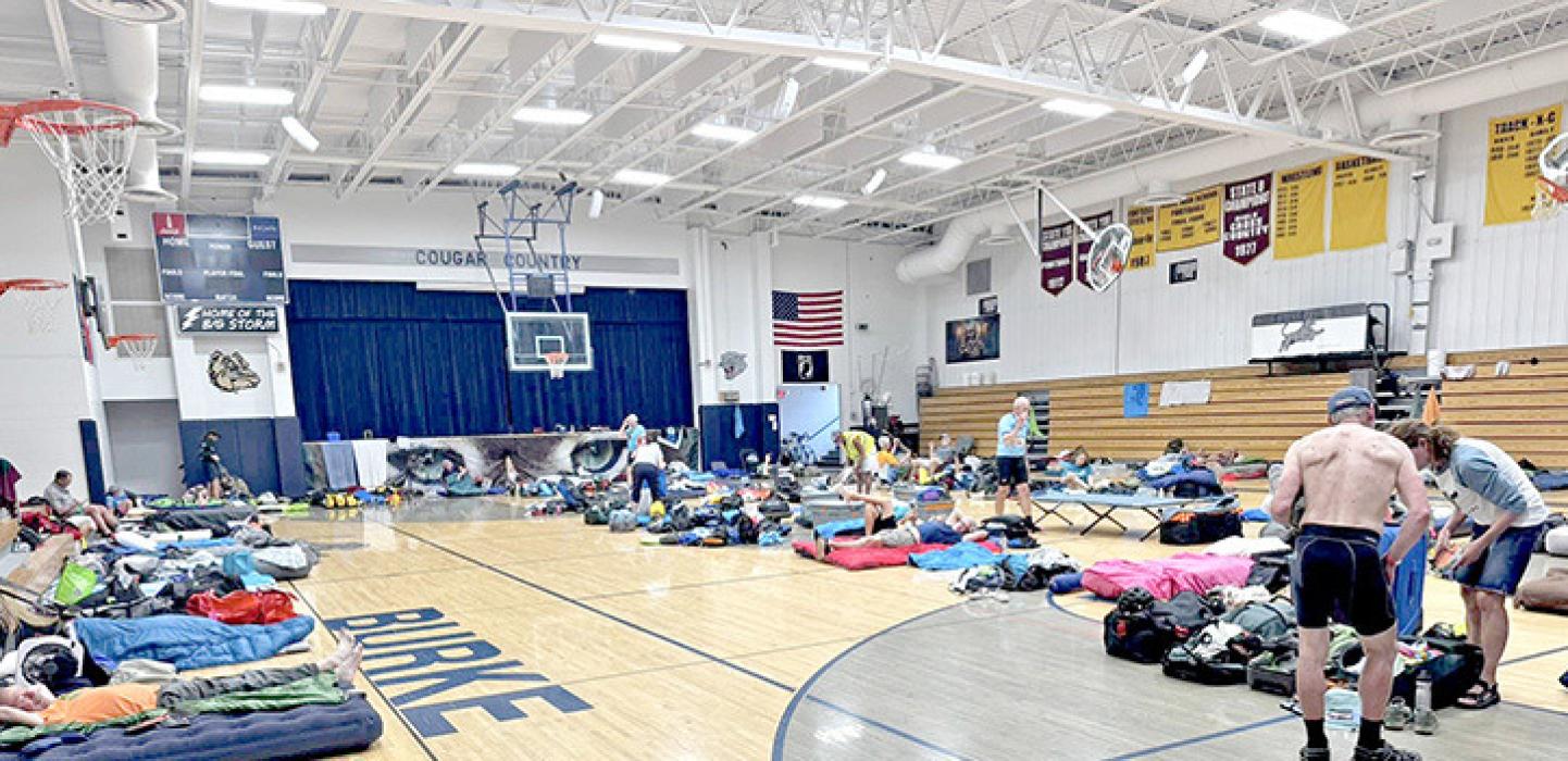 Cyclists set up their sleeping arrangements for the night in the gym. (Photo from RASDak Facebook page)