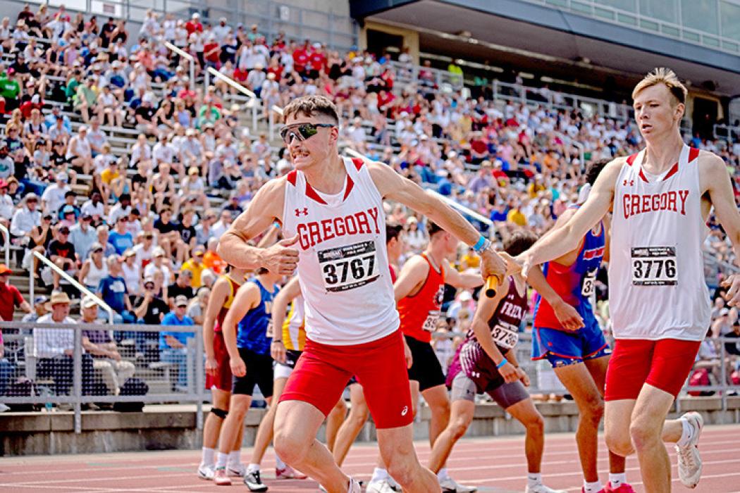 Fin Adams takes the baton from Colt Keiser in the 4x400 relay, where they placed 2nd. (Photo courtesy of SDPB)