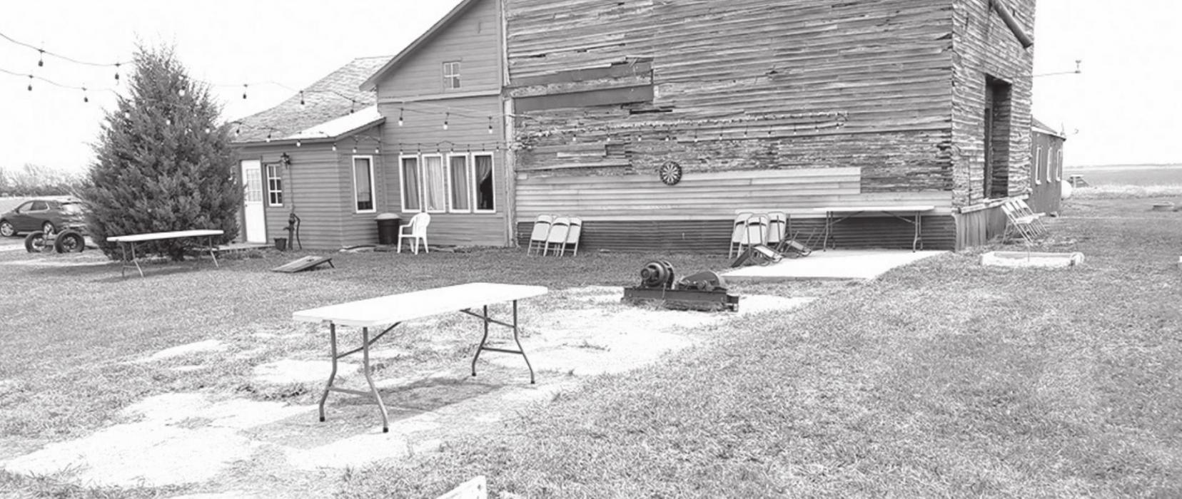 The entrance to the tavern is on the west side of the building. The lawn is scattered with miscellaneous antiques that Dennis has uncovered, as well as yard games and seating.