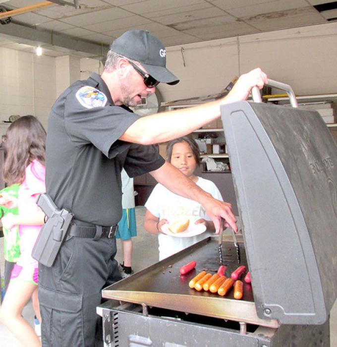 Gregory Police Officer Ryan Cook grilled brats and hot dogs, donated by Buche Foods, and the EMTs donated water for the attendees.