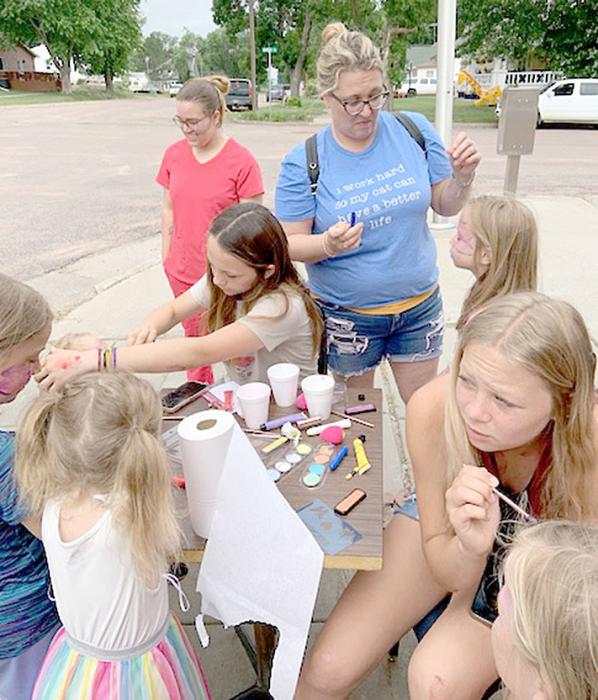 Abby Holmes and Miley Janak set up a stand for face painting.