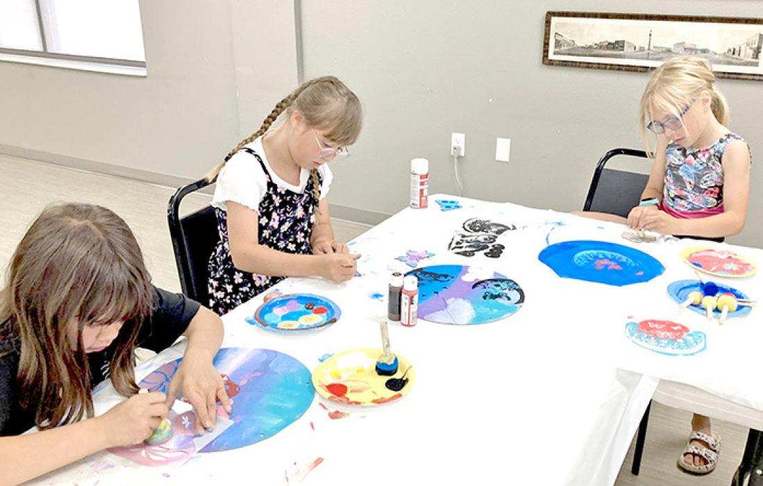 On Tuesday, June 17, 2025, youth participated in a stencil painting workshop hosted by Sandy Williams. During the workshop, they used stencils to create artwork on wood. They learned valuable skills such as patience, how to plan the layout of their stencils, and techniques for creating fun, ombre backgrounds. The youth made many stunning creations and were excited to bring them home to share with their families.