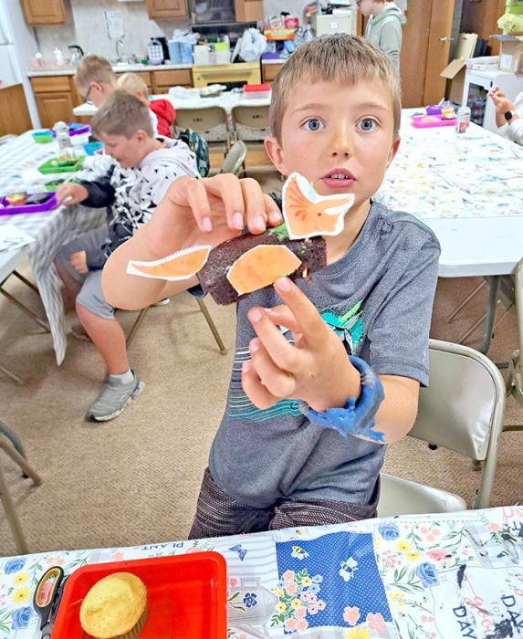 Participants in a Gregory Public Library summer program put their creativity to work by constructing dinosaur- themed treats from cake. The activity was made possible with help from Library Board members Barb Beehler and Guyla Husman, who assisted with baking, and weekly sponsor Mr. Automotive, which provided snacks and supplies. Dinosaur Creations Take Shape