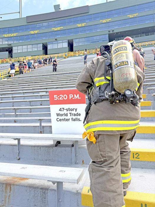Mark Braun, in full turnout gear, makes his way up to the 47th story. An already emotional climb, the sign is a reminder of when the tower fell.