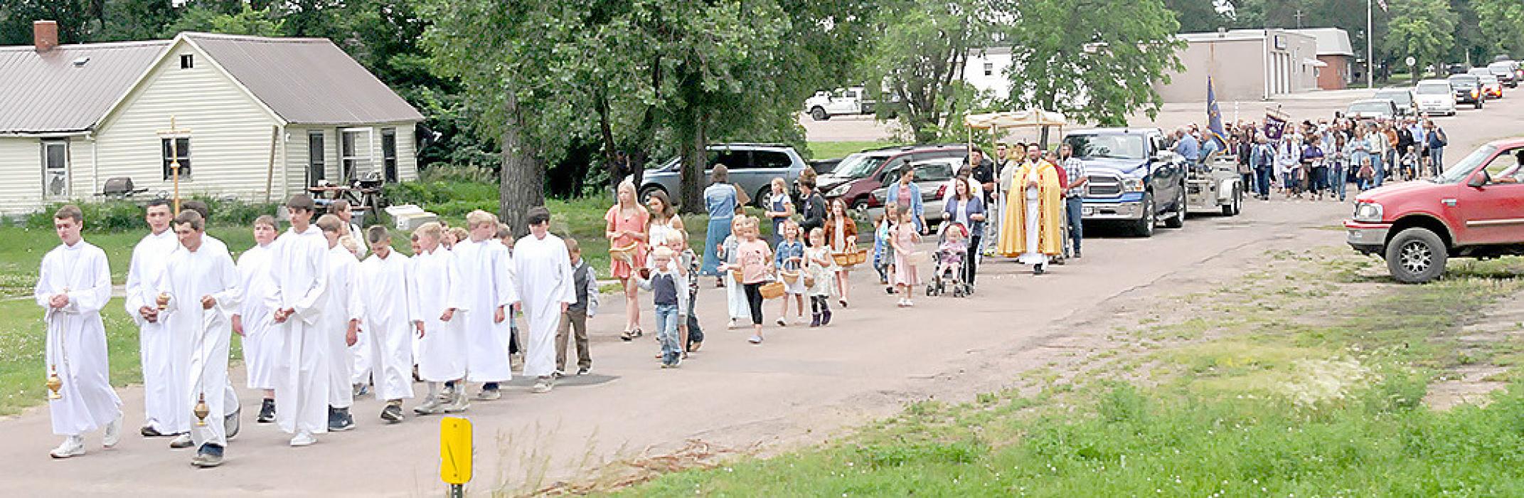 Altar servers led the procession, carrying incense and the cross. Behind them were palm bearers, flower girls, Fr. Godfrey and Deacon Ekroth. Fr. Dillon carried the Blessed Sacrament, walking under a canopy supported by men from the different parishes. They were followed by musicians and a prayer leader, the Catholic Daughters and Knights of Columbus, and lots and lots of people walking and driving their vehicles. The Gregory Police Department provided an escort at the beginning of the procession.
