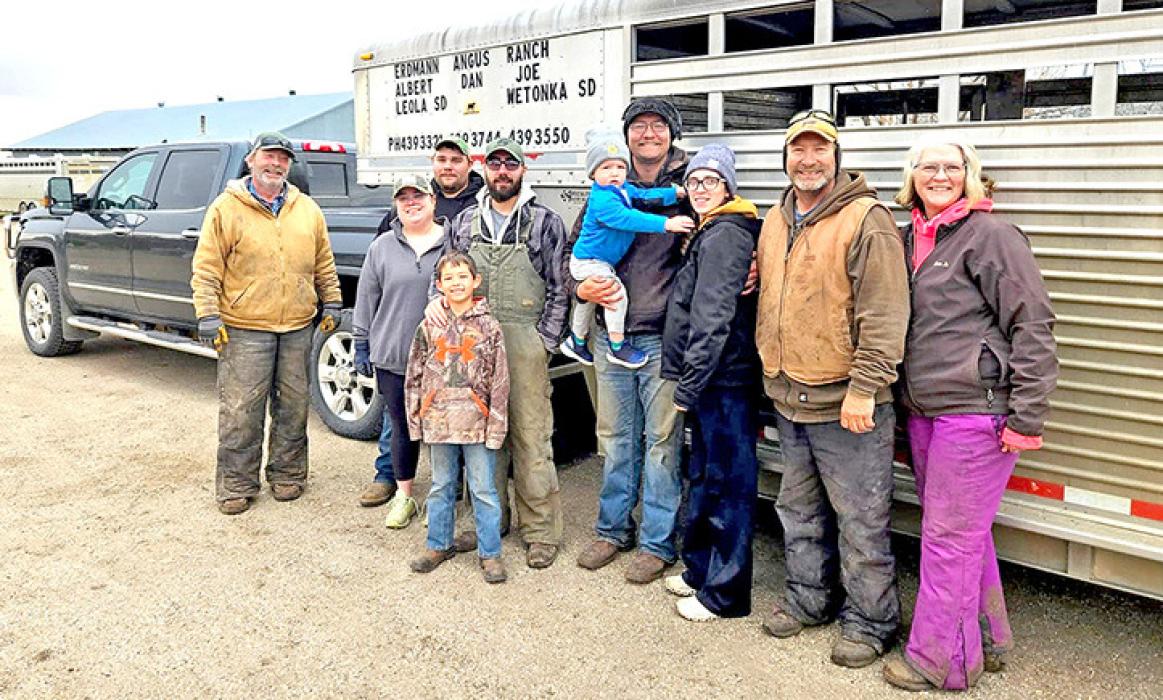 Anne Jo Erdmann, far right, stands with her family after loading heifers onto a tractor-trailer near Leola, S.D., on April 26, 2025. (Photo: Megan Luther/ South Dakota News Watch)