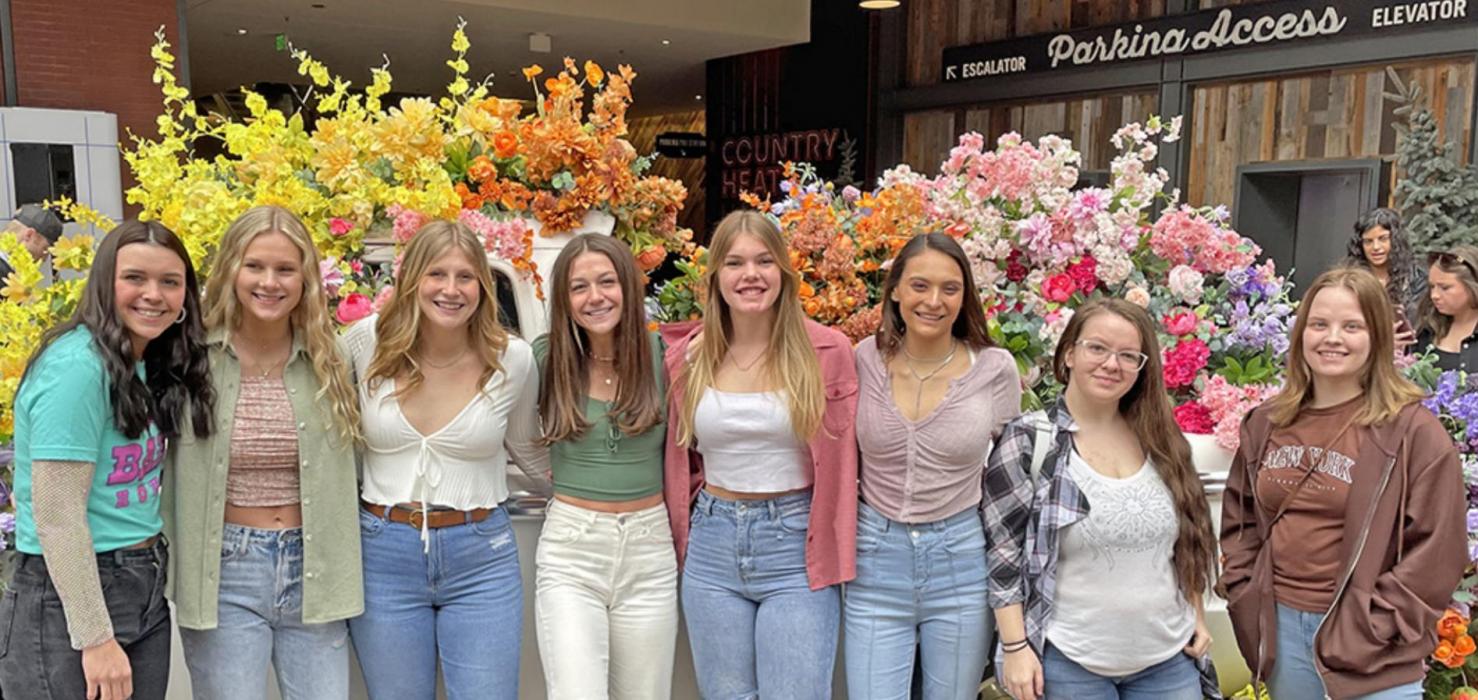 No vacation is complete without some shopping time. The girls are shown here in front of a large display of flowers at a shopping area.