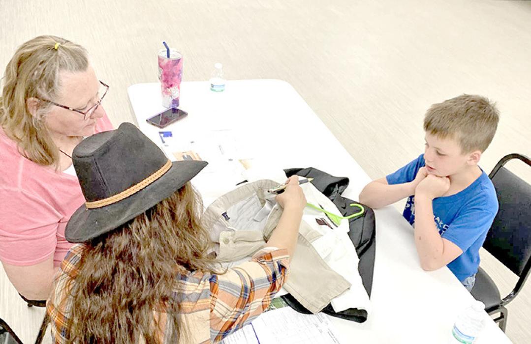 Judges discuss features of Owen Schulte’s garments as he listens.