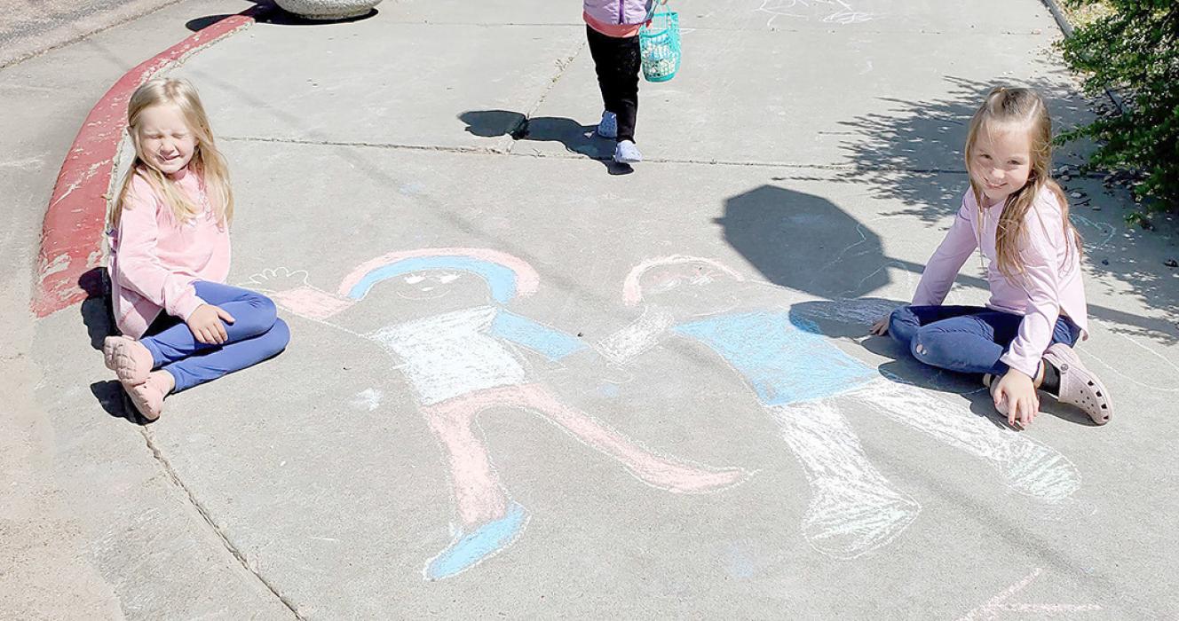 Kendall Braun, l, daughter of Mat and Nicole Braun, and Vayah Braun, daughter of Mike and Kristin Braun, pose with their sidewalk art.