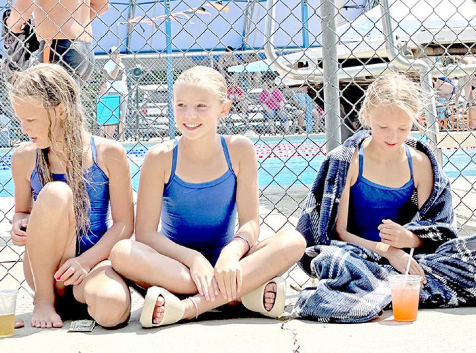 Brenlee Braun, Averie Stukel, and Mayme Reber relax between events.
