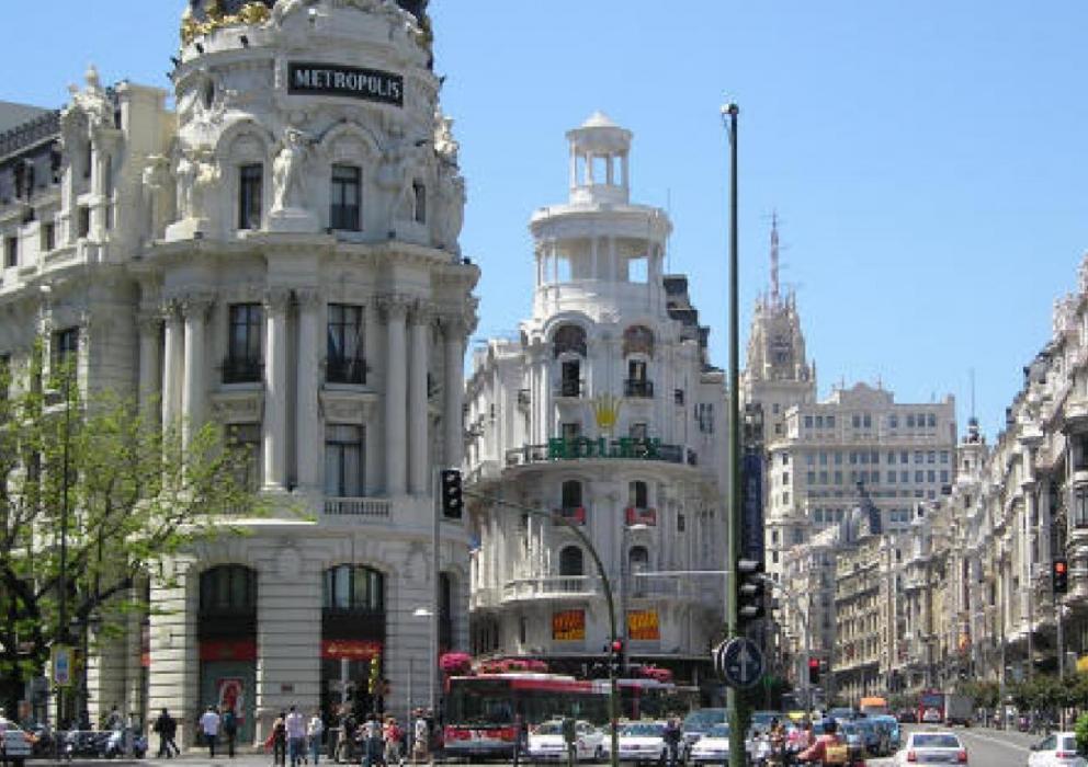The Edificio Metropolis is a beautiful Parisian-style building located at the intersection of Gran Via and Calle de Alcala in Madrid, Spain. Built in 1905, this ornate structure is surrounded by many other elegant buildings from the same period.