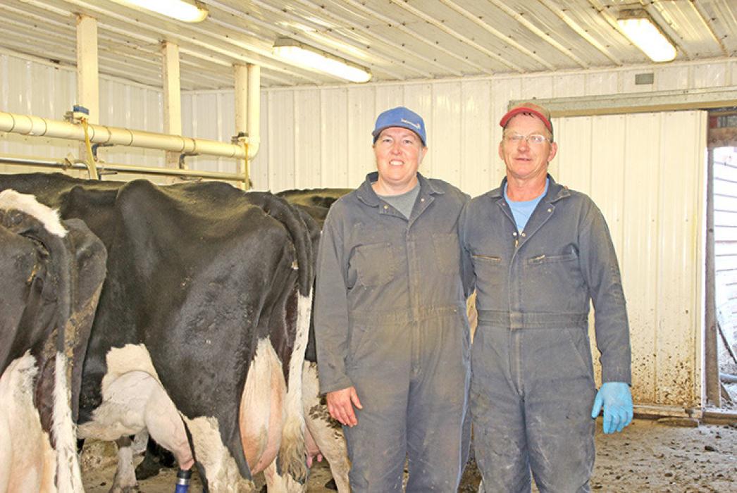 Verlyn and Dana Jons stand in their stanchion barn April 22 on their dairy near St. Charles, South Dakota. They are the last dairy in Gregory County. (Photo by MLPhotography)