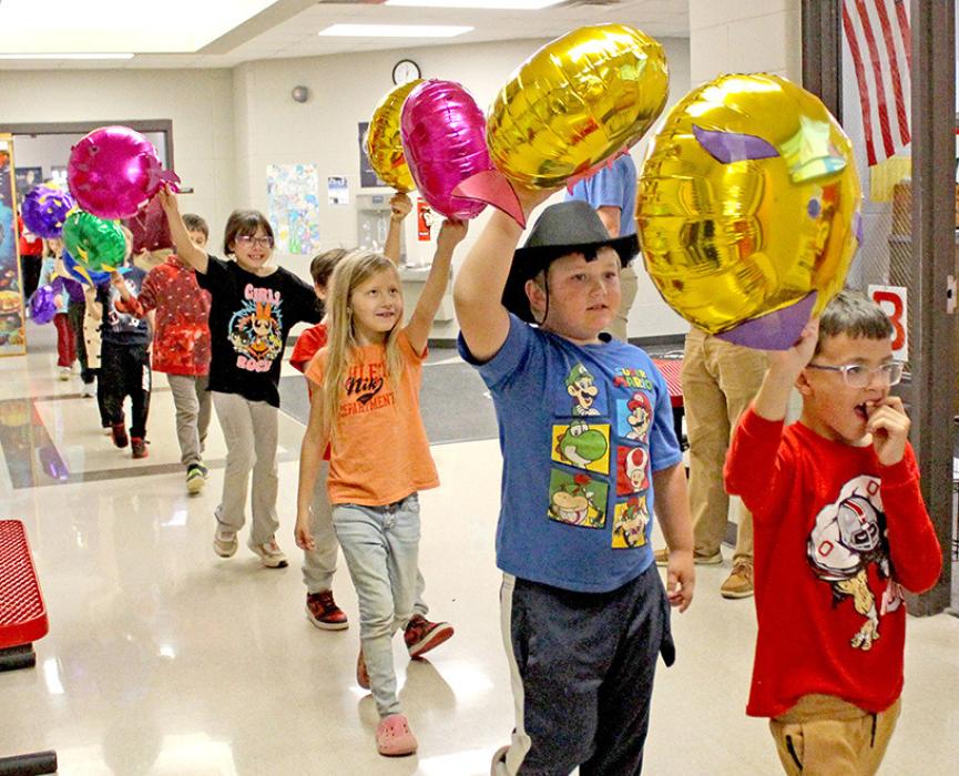 Colorful rainbow fish balloons floated through with the second graders.
