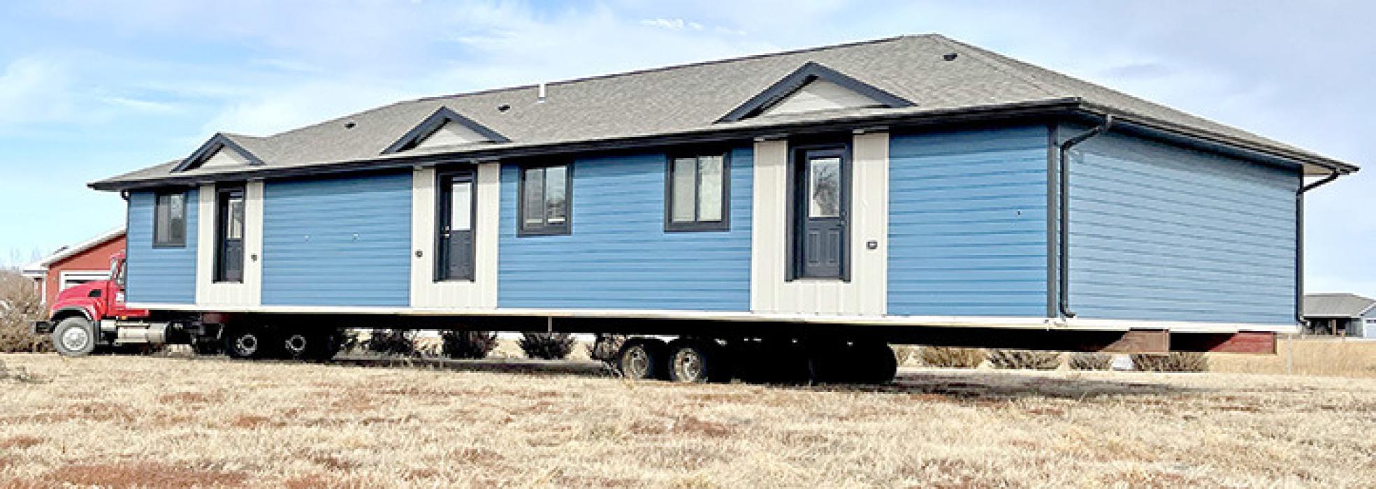 Workforce housing from Jensen Design Build in Mitchell makes its way across the Platte-Winner Bridge Thursday, December 21, 2023, along with a house on its way to Burke. The workforce housing is now set on a lot across the street from the new hospital, on the north side. It will be fully furnished and available for rent for short-term stays. (Photo used by permission from Jensen Design Build, LLC)