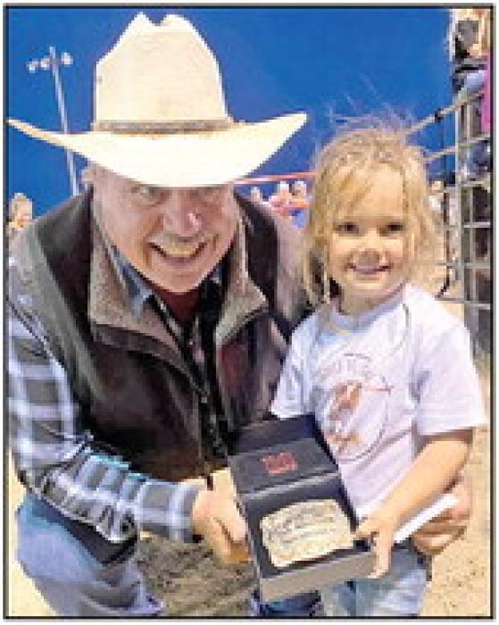 Bruce Boes (l) presents Evelyn Miller (r), the 0-4 age division champion her buckle. 2nd place was won Tierney Feddersen, 3rd place Layke Beck, and 4th place Laramie Helkenn.