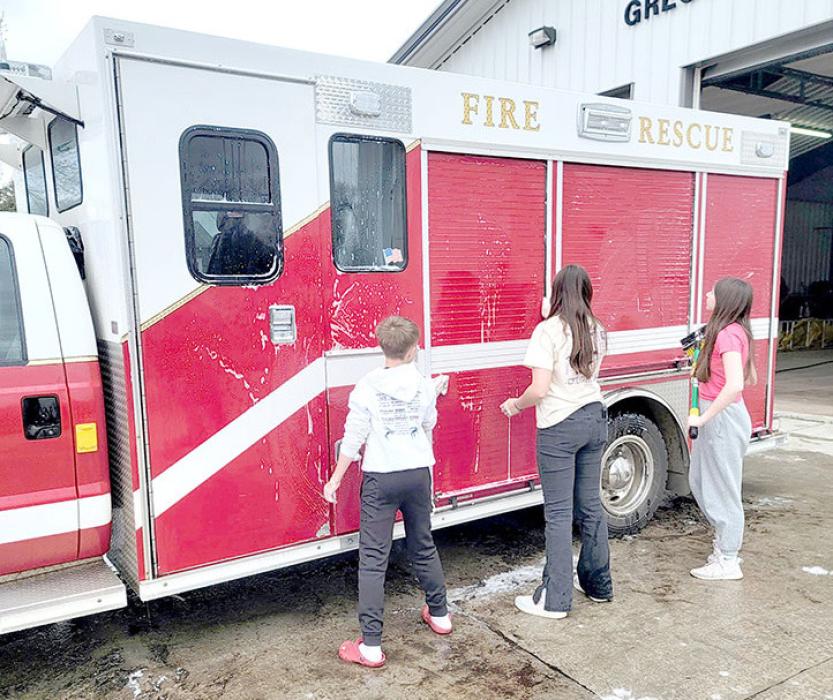 Seventh and eighth grade students washed vehicles for the ambulance, police department, and fire department.