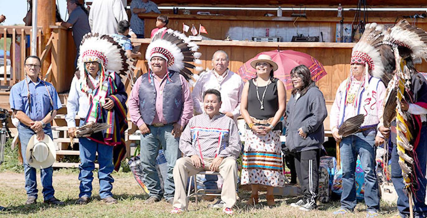 William Bearshield, seated, is surrounded by several chiefs and tribal leaders. His niece, Lisa White Pipe, is shown to the right of him.