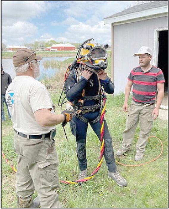 The diver’s helmet, outfitted with a camera and microphone weighs around 40 pounds on land, but most of that weight is negated in the water. An umbilical cord supplies oxygen and communication lines.