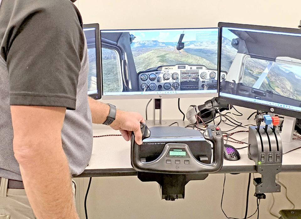 Mr. Murray lines up the airplane with the runway on the flight simulator.